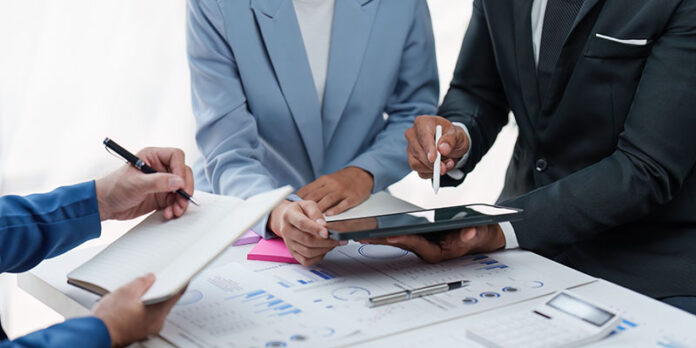 Close up of Diverse colleagues gather brainstorm discuss financial statistics at office meeting. finance, teamwork, Big data Graphs Charts concept