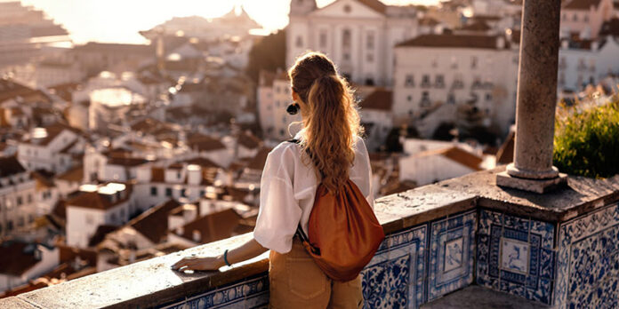 Female tourist looking at old town from balcony
